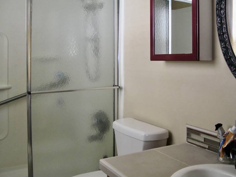 A bathroom with a glass shower door

Description automatically generated with low confidence