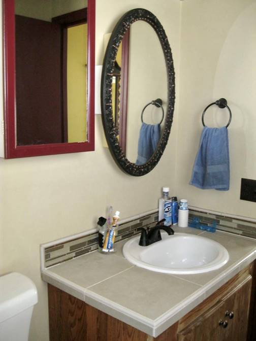 A bathroom with a mirror and a sink

Description automatically generated with low confidence